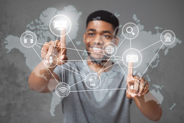 Cheerful african-american man pushing world map interface