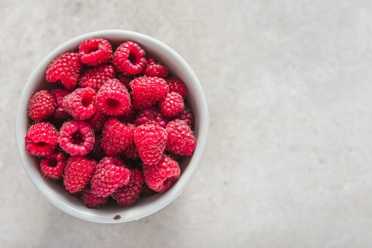 Fresh raspberry in a bowl, top view