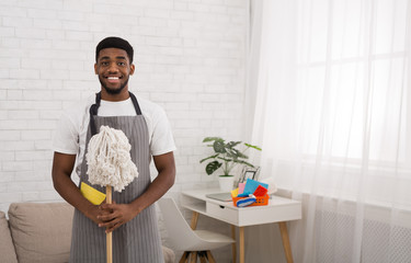 Black man with mop cleaning floor at home