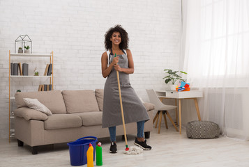 Black woman smiling with mop and bucket