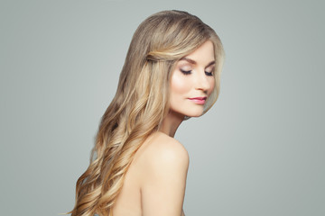 Pretty blonde woman with long healthy hair and clear skin. Facial treatment, spa and cosmetology