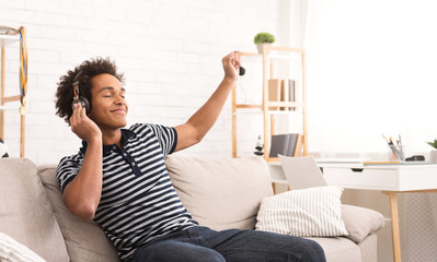 Enjoying favorite music. Teenager listening to music and dancing