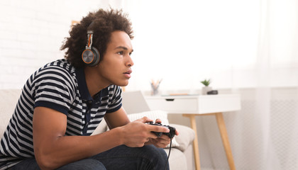 Concentrated teenager playing video games with joystick