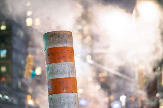 Fototapeta Steam pipe on the street in Manhattan at night in winter, New York City