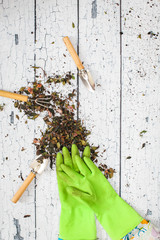 Rubber green safety gloves hand shovel and gardening rake on wooden board agriculture concept.