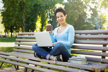 Fototapeta premium Female freelancer working with laptop outside