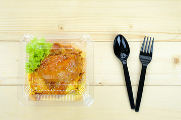 Creamy omelette with spicy chiken on rice(Kao Khai Kon Kai Sap) within plastic container, on the...