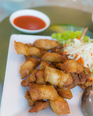 Fried Streaky Pork in white dish on glass table background,