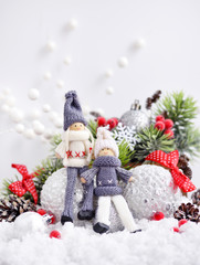 Christmas composition with toys dolls and spruce branches and festive decorations on snow. Christmas or New Year greeting card.
