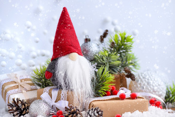 Christmas composition with the gnome, gifts and festive decorations оn the snow. Christmas or New...