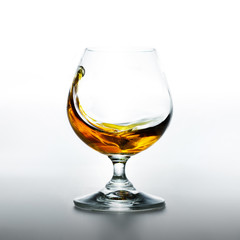 Cognac glass with splashing brandy inside