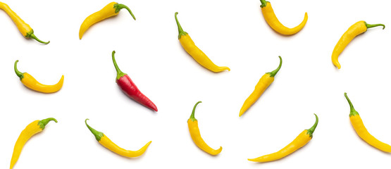 One red chilli pepper among yellow on white background.
