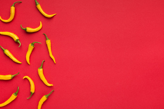 Hot Yellow Chilli Peppers On Red Background