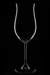  Transparent blank empty wine glass over black background.