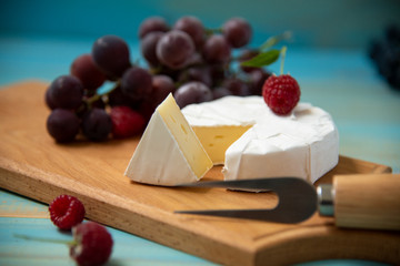 cheese camembert or brie on blue wooden background