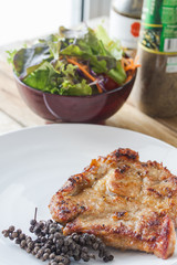 Pork neck steak with vegetables and pepper