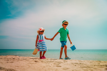 cute boy and girl walk on tropical beach vacation