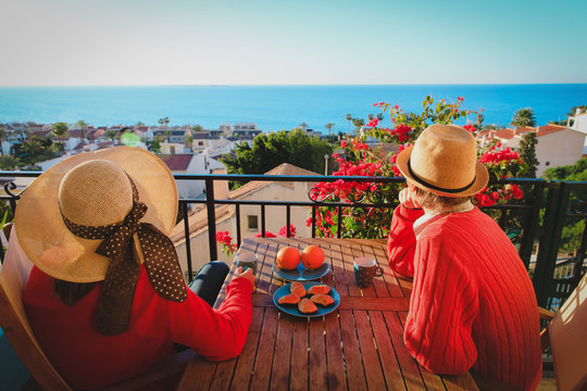 romantic couple having breakfast on balcony terrace with sea view