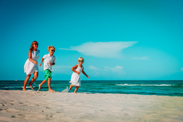 mother with kids play run on tropical beach