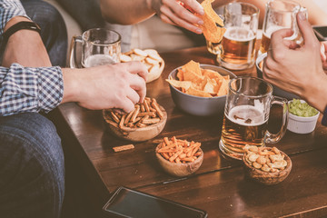Young people at a beer party with snacks, watching football, toned,