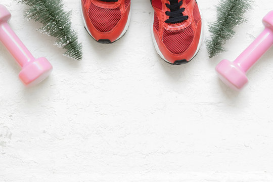 Christmas healthy acive lifestyle flat lay composition with sneakers, dumbbells, christmas tree on grunge white wood  background. Merry Christmas and Happy new year background special for healthy 