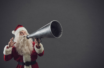 Santa Claus shouting with a vintage megaphone