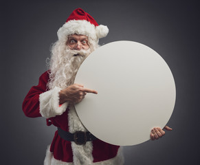 Santa Claus holding a round commercial sign