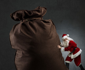 Santa pushing a huge sack with gifts