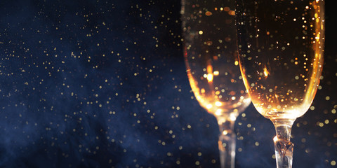 Christmas decoration with two glasses of champagne and lights on a wooden background, Happy New Year.
