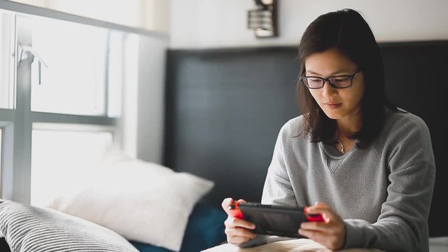 Young woman playing console game at her room.