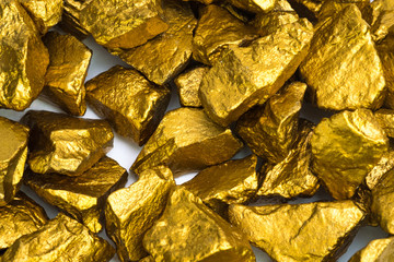 A pile of gold nuggets or gold ore on white background, precious stone or lump of golden stone, financial and business concept.