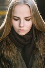 Portrait of young woman at sunny winter day.