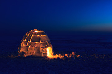 A snowy house called an igloo at sunset. - obrazy, fototapety, plakaty