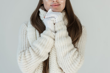 cropped image of woman in fashionable winter sweater and scarf isolated on white