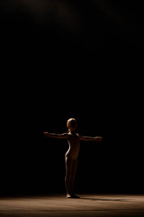 Obraz na płótnie Canvas Very young ballerina posing on a black background