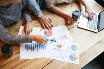 Group of students having a business lunch indoors analysing data close-up