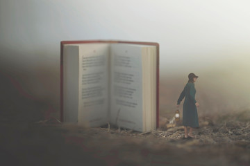 surreal moment of a woman with lantern walking confused in the fog between giant books