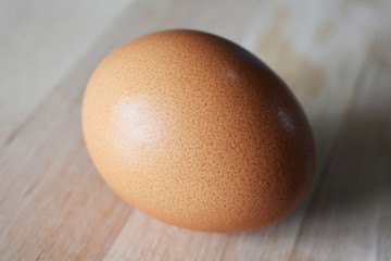 closeup of chicken egg on wooden background, texture of egg shell