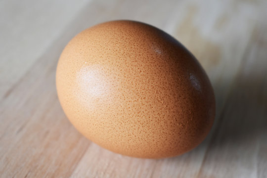 closeup of chicken egg on wooden background, texture of egg shell
