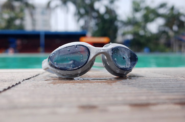 Fototapeta na wymiar Swimming goggles on the floor near the swimming pool
