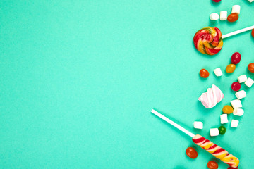 Colorful candies on pastel turquoise background. Flat lay