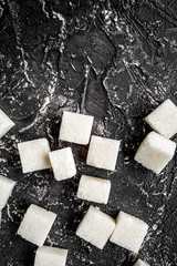 lumps of sugar sweet set on dark table background top view mocku