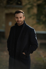 handsome smiling man in black coat