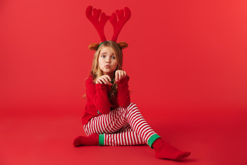 Cheerful little girl wearing Christmas raindeer costume