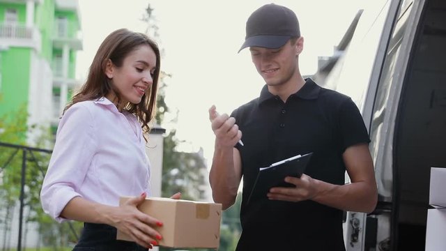 Delivery Courier Service. Man Delivering Package To Woman