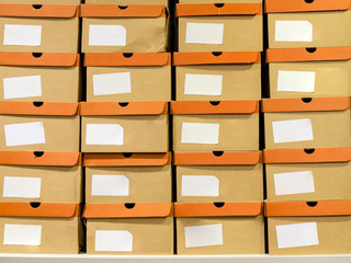 Shoeboxes standing on a shelf in a shoe store. Cardboard boxes on rows of shelves in distribution...