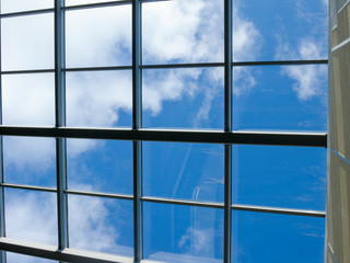 Fototapeta na wymiar Blue sky with white clouds through the window in the ceiling of a large building