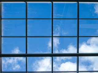 Blue sky with white clouds through the window in the ceiling of a large building