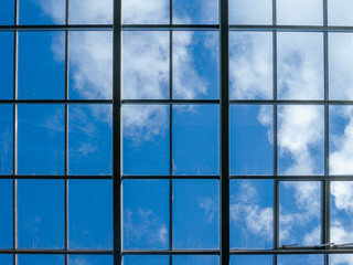 Blue sky with white clouds through the window in the ceiling of a large building