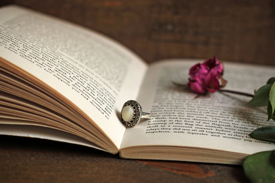 Ring, withered rose and book